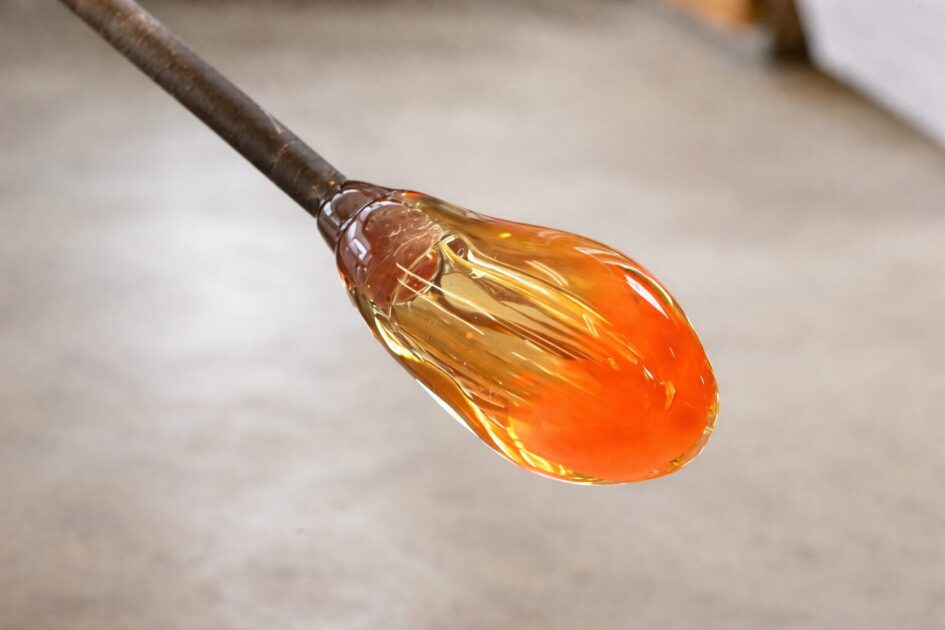 吹き竿の先端に巻き取った溶けたガラス。1300℃の熱で飴細工のようにオレンジ色に輝くのイメージ画像