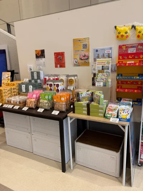 和倉温泉お祭り会館ロビーのお土産コーナー。ピカチュウのお面や能登のお菓子が並ぶ