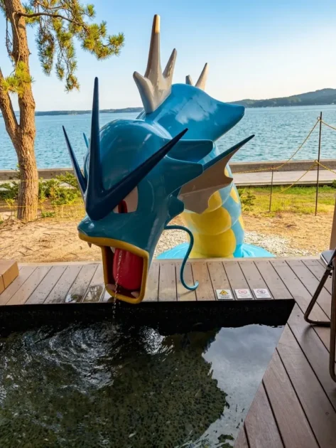 七尾湾を背に、足湯の湯船に顔を出すギャラドスの像