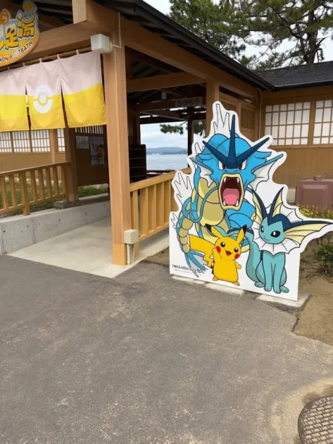 わくらポケモン足湯の入口。ギャラドス・ピカチュウ・シャワーズのパネルが立つ和風の足湯棟